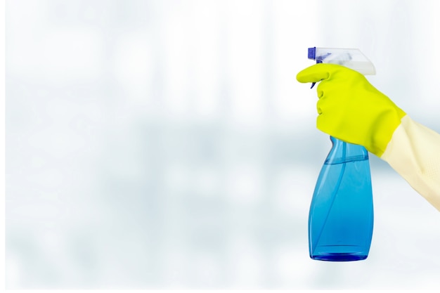 春の大掃除のコンセプト。クリーニングスプレーボトルを保持している保護手袋を手に入れます。コロナウイルスの発生に関する消毒または衛生の概念。
