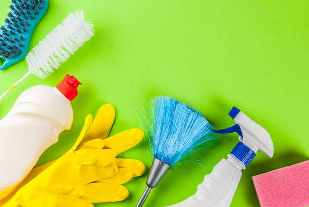 Spring cleaning concept with supplies, house cleaning products pile. household chore concept, on green background top view copy space