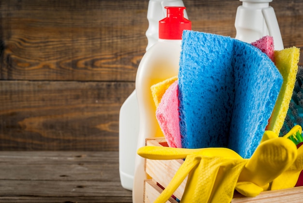 Spring cleaning concept with supplies, house cleaning products pile. household chore concept, on rustic or garden wooden background copy space