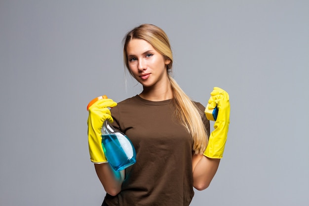 Spring cleaning woman pointing cleaning spray bottle isolated on gray