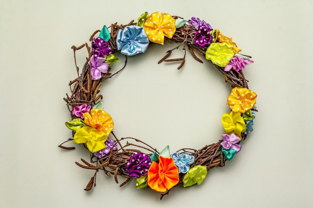 Spring composition of a wreath of birch branches and craft colorful flowers