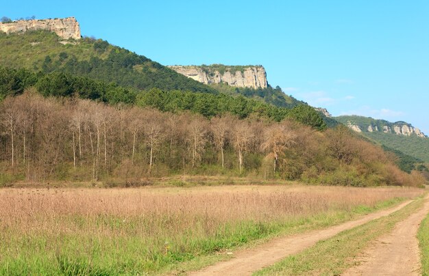 Spring Crimean mountain landscape and rural roads in valley (Mangup Kale - historic fortress and ancient cave settlement in Crimea, Ukraine)