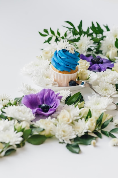 Spring cupcake on a white background with flowers and\
fruits