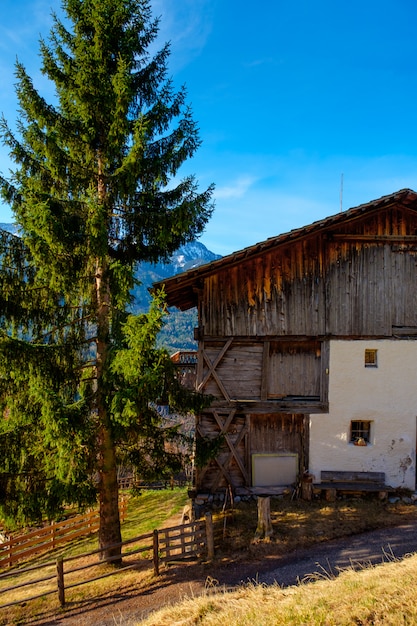 Spring in the Dolomites. A view of the houses standing on the green slopes of the mountain. Villages San Pietro snd Santa Maddalena.