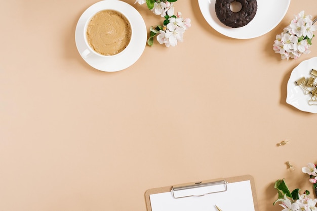Spring flat lay with apple flowers Woman's workplace Tea break with Donut Copy space