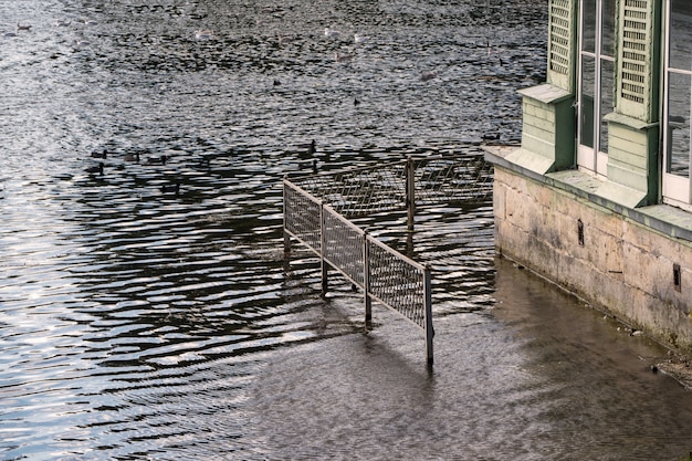 Spring flood of water in the river. High water, house flooded with water.