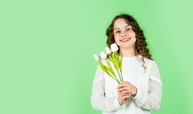 Весенний букет цветов счастливый женский день международный день защиты детей день матери концепция веселая маленькая девочка с вьющимися волосами тюльпаны цветы для ребенка счастливая девушка держит тюльпан цветы копия пространства