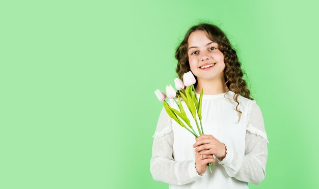 봄 꽃 꽃다발 해피 여성의 날 국제 어린이 날 어머니의 날 개념 곱슬 머리 튤립 꽃을 가진 쾌활한 소녀 행복한 소녀는 튤립 꽃 복사 공간을 보유