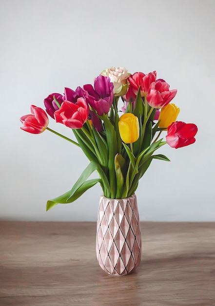 Spring flower bouquet of multicolored tulips in pink vase