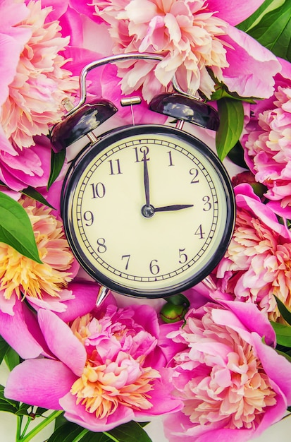 Photo spring flowers and alarm clock. change the time.