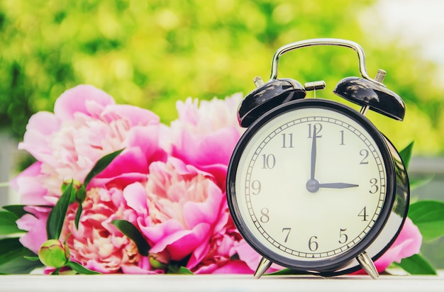 春の花と目覚まし時計。時間を変更してください。