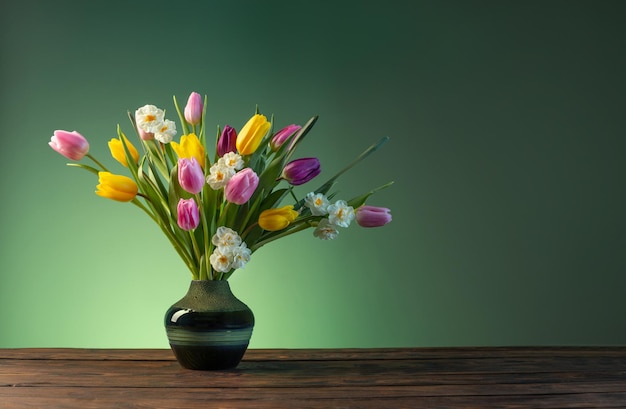 木製のテーブルの上の陶製の花瓶の春の花