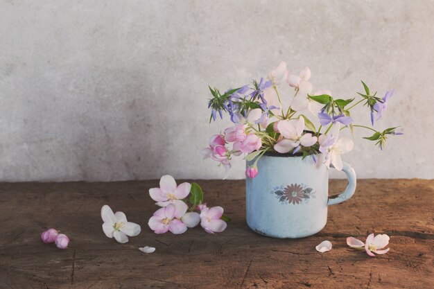 木製のテーブルの上にカップの春の花