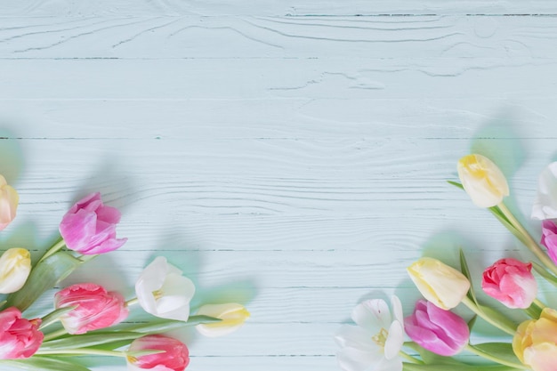 Spring flowers on green wooden background