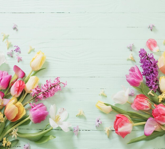 Spring flowers on green wooden background