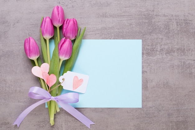 Spring flowers, greeting card, pastel color tulips on the gray background.