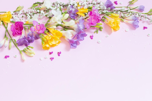 Spring flowers on pastel pink background