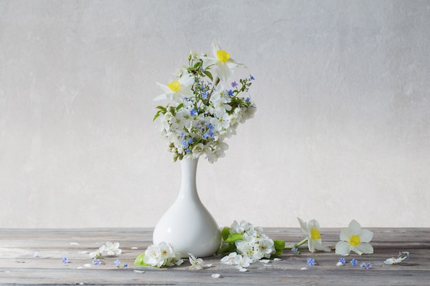 Spring flowers in vase on wooden table