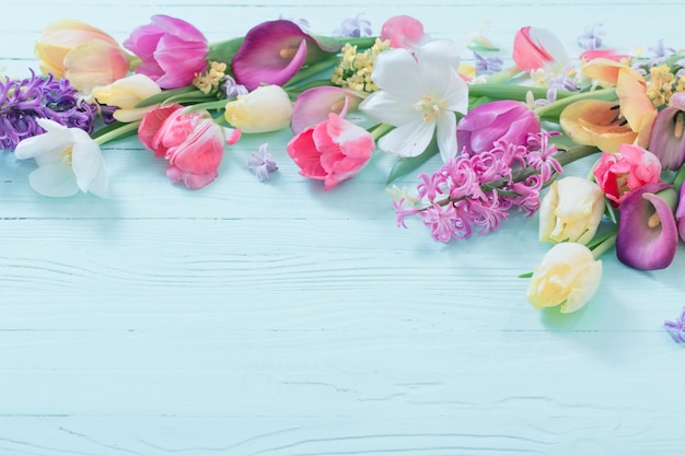 Spring flowers on white wooden background