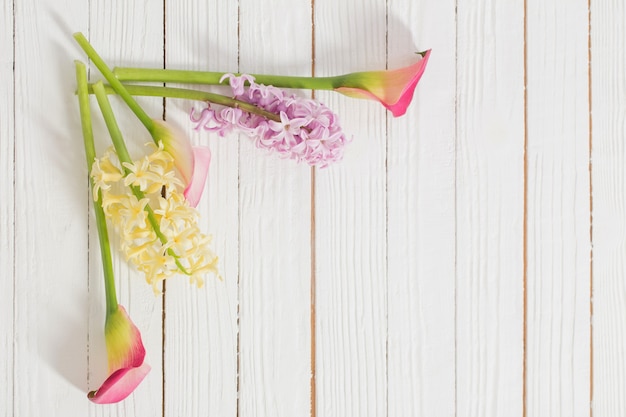 Spring flowers on white wooden surface