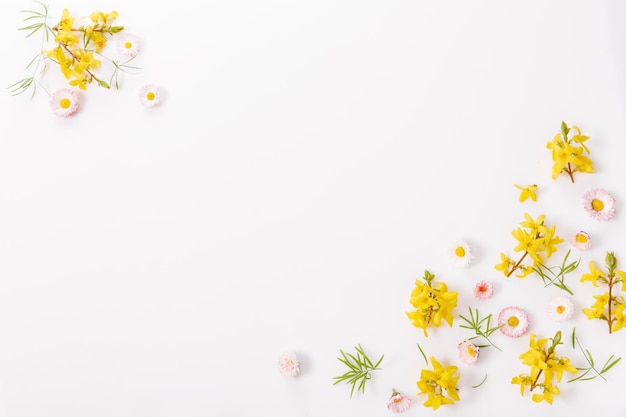 Spring frame of small flowers and daisy floral arrangement on white background Spring summer easter concept Flat lay top view copy space