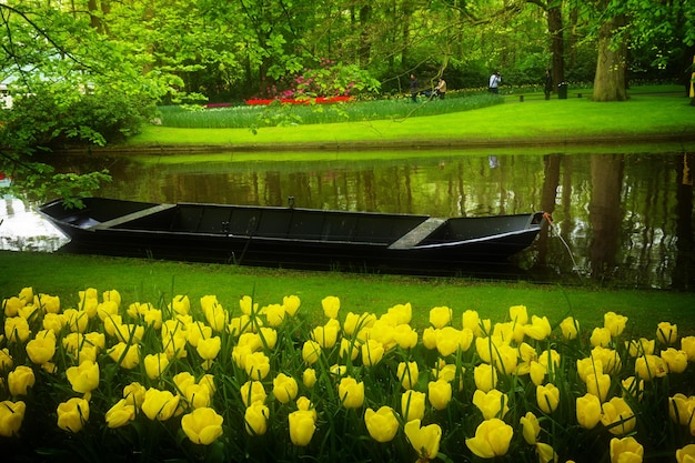 Photo spring garden with  water canal and boat   keukenhof holland