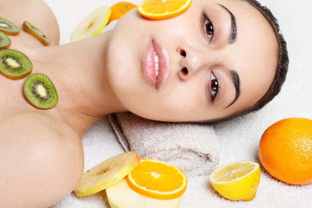 Spring, health, people, youth and beauty concept -Natural homemade fruit facial masks. Fresh fruit. Spa Woman applying Facial cleansing Mask. Beauty Treatments