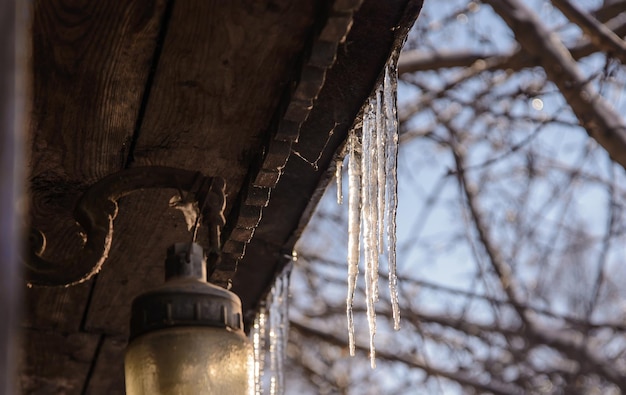 Spring icicles hanging from the roof of the old house