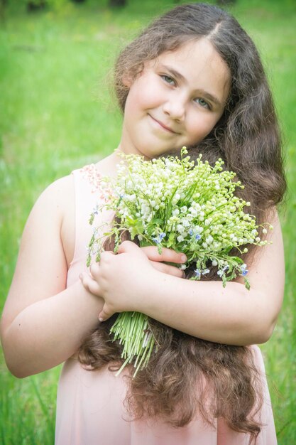 写真 森の春小さな花束を持った小さな女の子谷のリリー