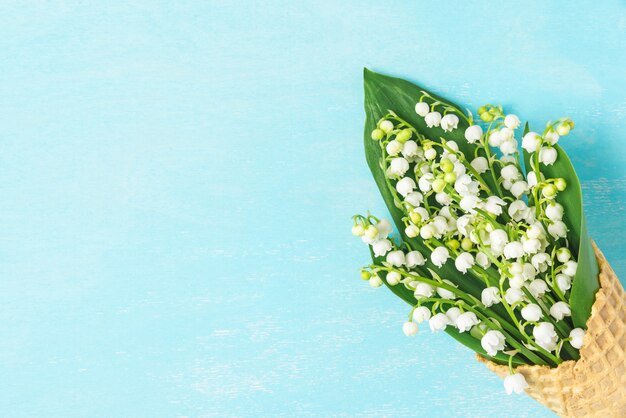 Spring lily of the valley flowers in waffle cone . Minimal spring concept. flat lay. top view