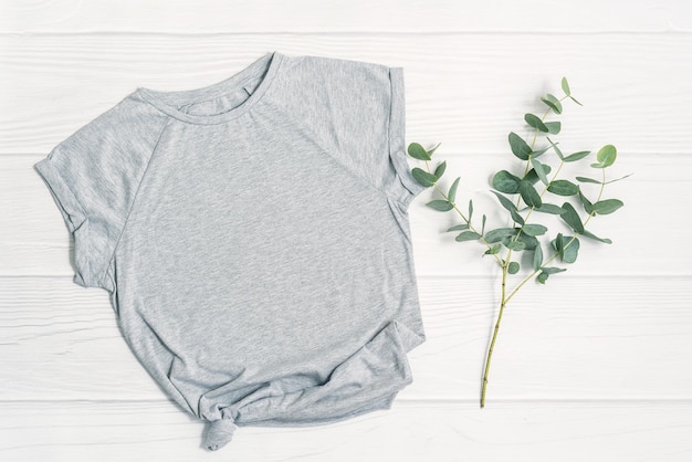 Photo spring mockup gray tshirt blank template and fresh green eucalyptus plant branch on white wood