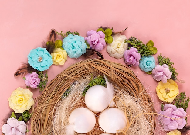 Foto mood primaverile, decorazioni pasquali di uova, fiori di carta, una corona di viti su uno sfondo di corallo vivente. banner largo - immagine.
