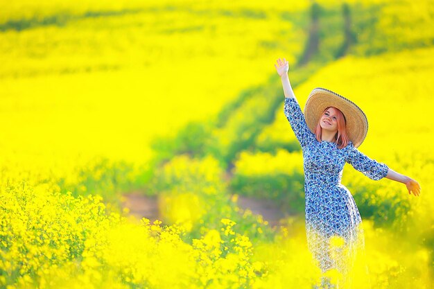 Spring nature young girl in a field of flowers, freedom and happiness of a lady in a sunny landscape