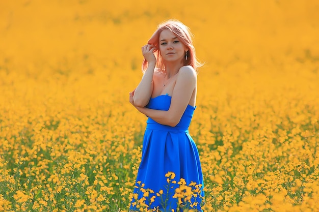 Spring nature young girl in a field of flowers, freedom and happiness of a lady in a sunny landscape