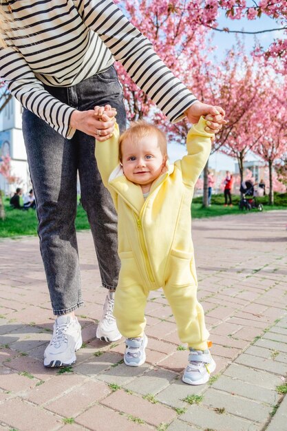 ウォーキングの練習をするお母さんと息子と春の公園散歩