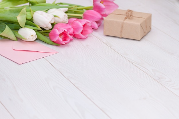 Spring pink tulips, gift box and empty paper card. Mother's Day concept.