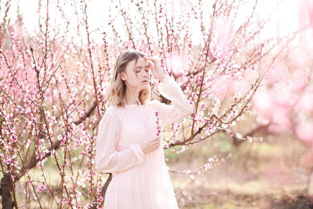 桃の花を持つ美しい少女の春の肖像画