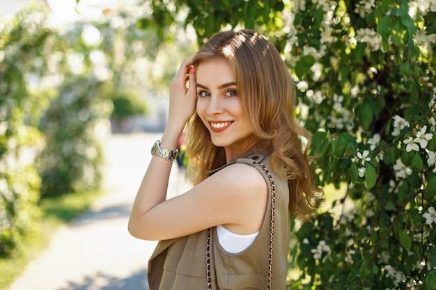 Spring portrait of a young beautiful girl with a smile in the park
