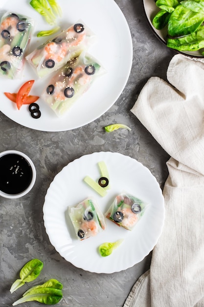 Spring roll cut in half in rice paper with seafood and vegetables on a plate Top an vertical view