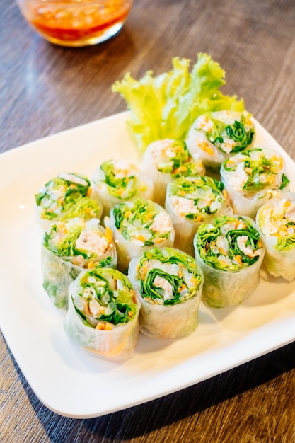 Rotolo di primavera in piatto bianco con salsa