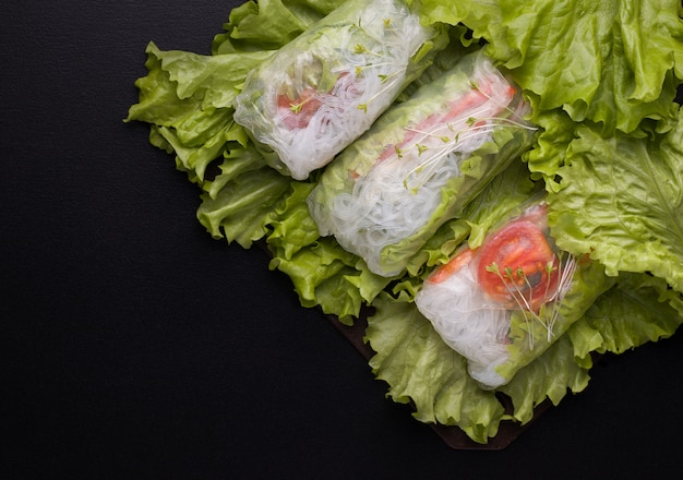 Spring rolls with vegetables in rice paper on black.copy spaces