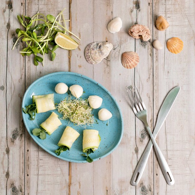 Spring rolls with zucchini and mozzarella cheese. Food with micro greens on wooden table