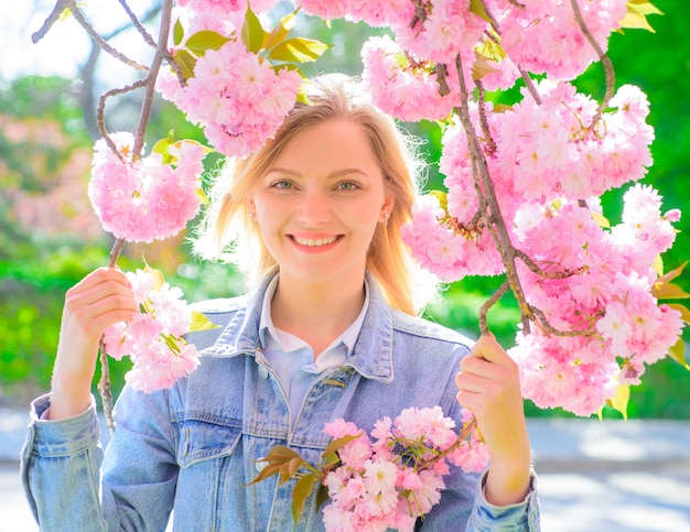 Spring romantic woman portrait woman in sunny day spring woman in cherry bloom girl with sakura