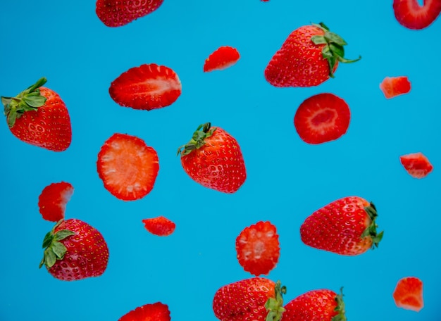 Spring season strawberry in air on blue surface. Above view