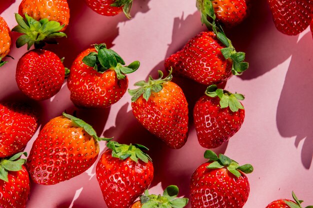 Spring season strawberry on pink surface. Above view