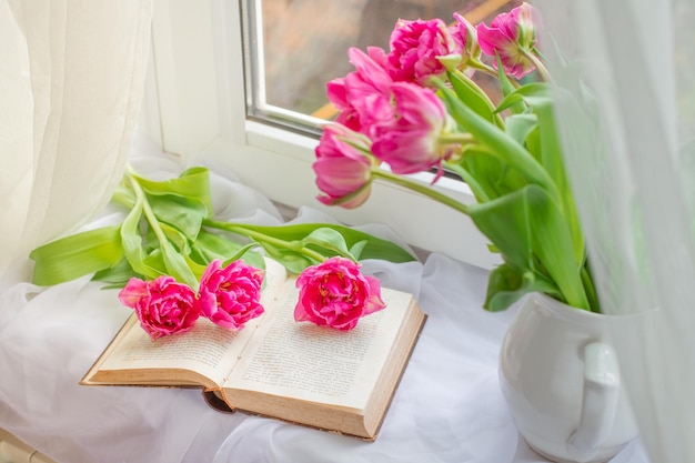 봄 정물 튤립 꽃다발 차 한 잔 창문에 있는 오래된 프랑스 책