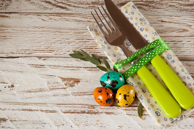 Spring table place setting with colored quail eggs.