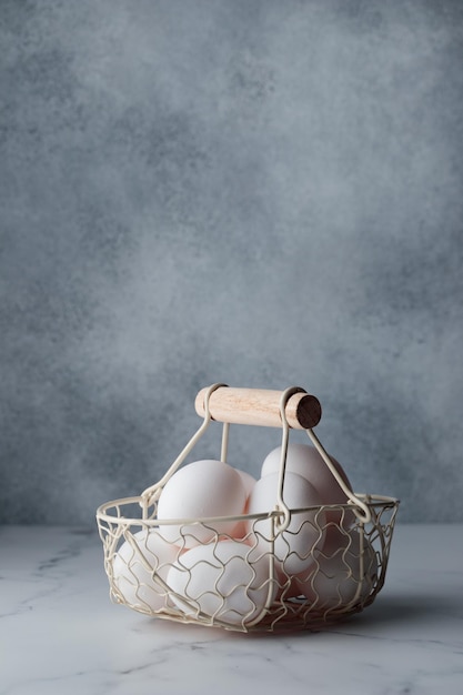 Spring time easter holidays white eggs in a basket gray table