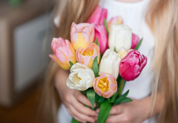 Весенние тюльпаны в руках маленькой девочки