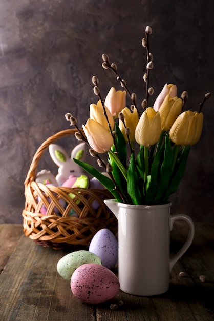 Foto tulipani della primavera con le uova di pasqua su fondo rustico